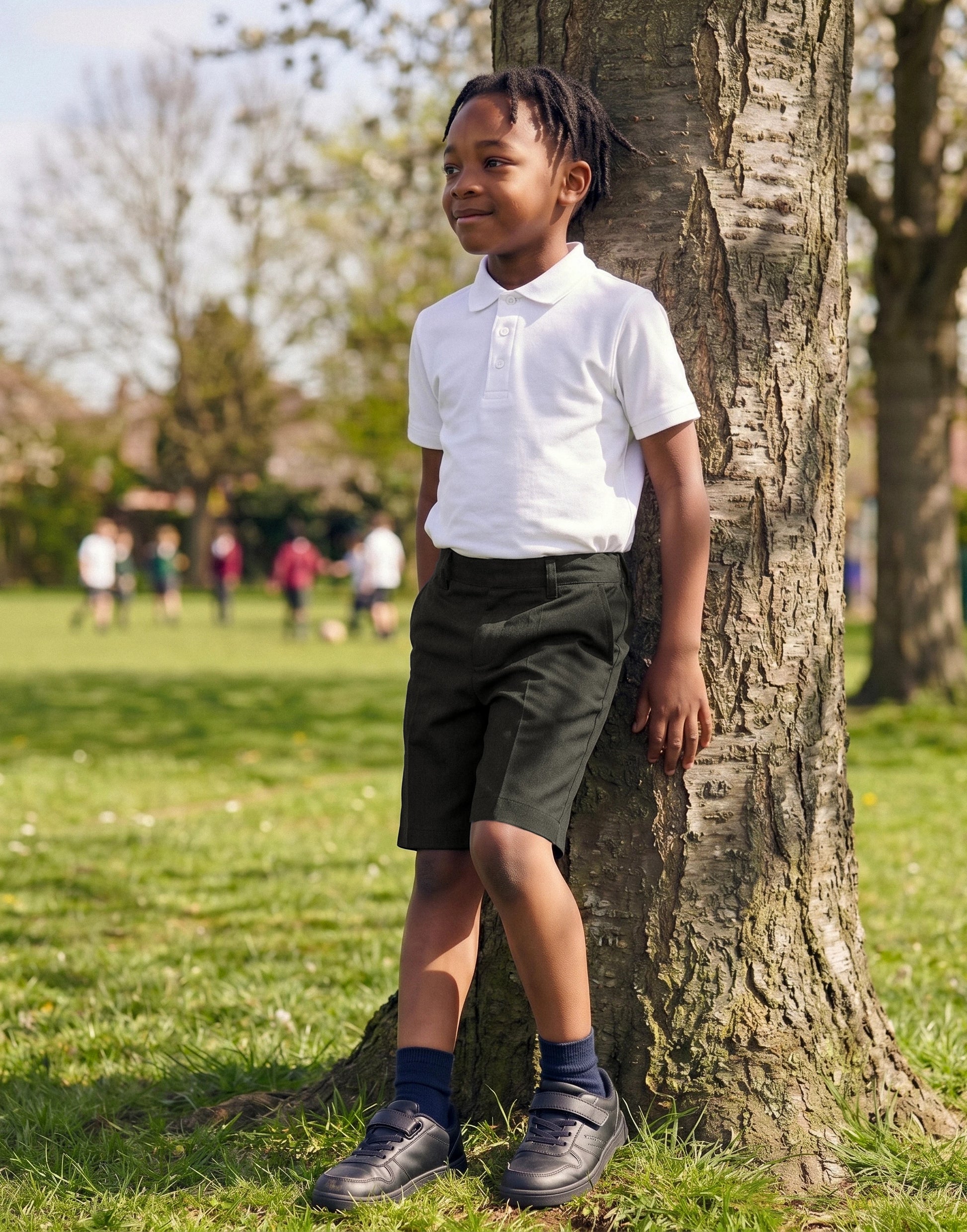 Boy wearing charcoal classic fit organic cotton school shorts, front view