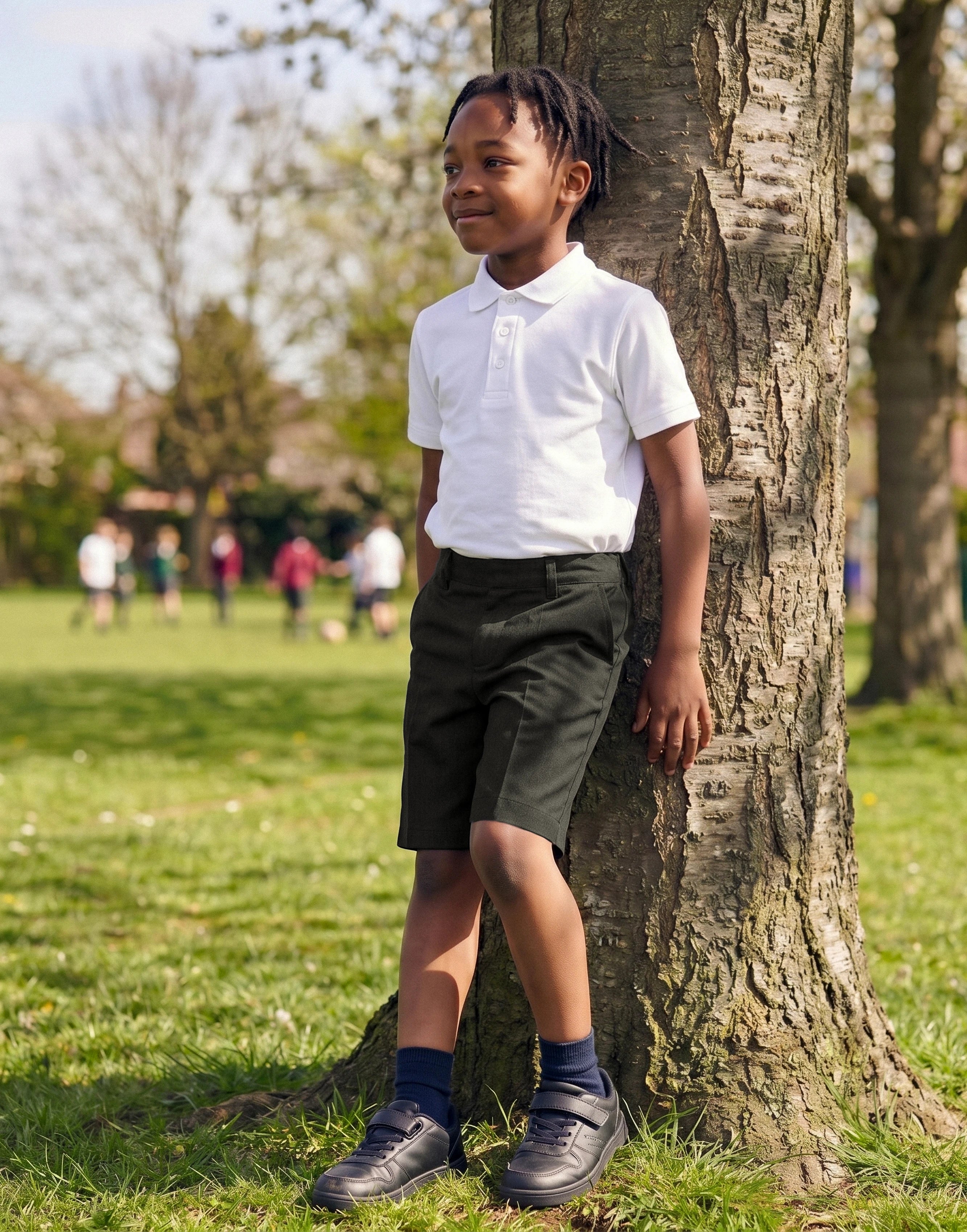 Boy wearing charcoal classic fit organic cotton school shorts, front view