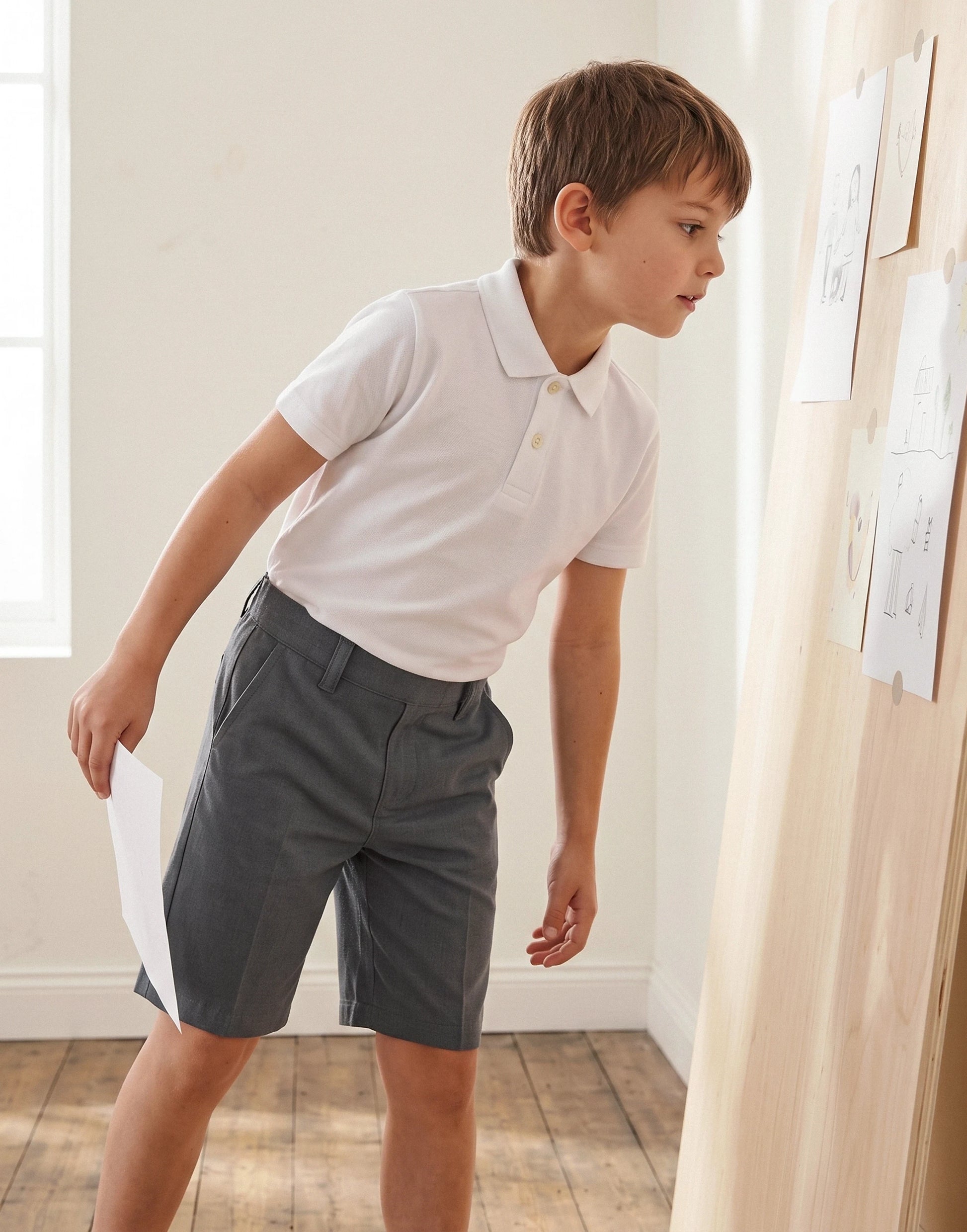 Boy wearing grey classic fit organic cotton school pull on shorts, side view