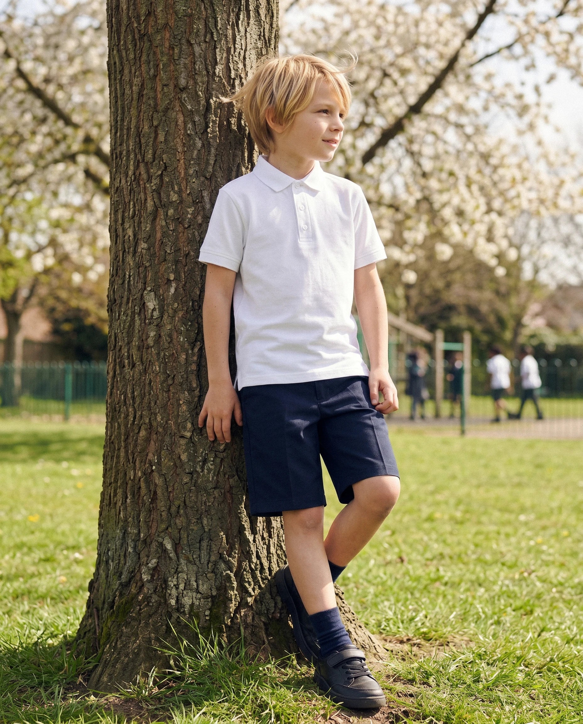 Boy wearing navy classic fit organic cotton school shorts, front view