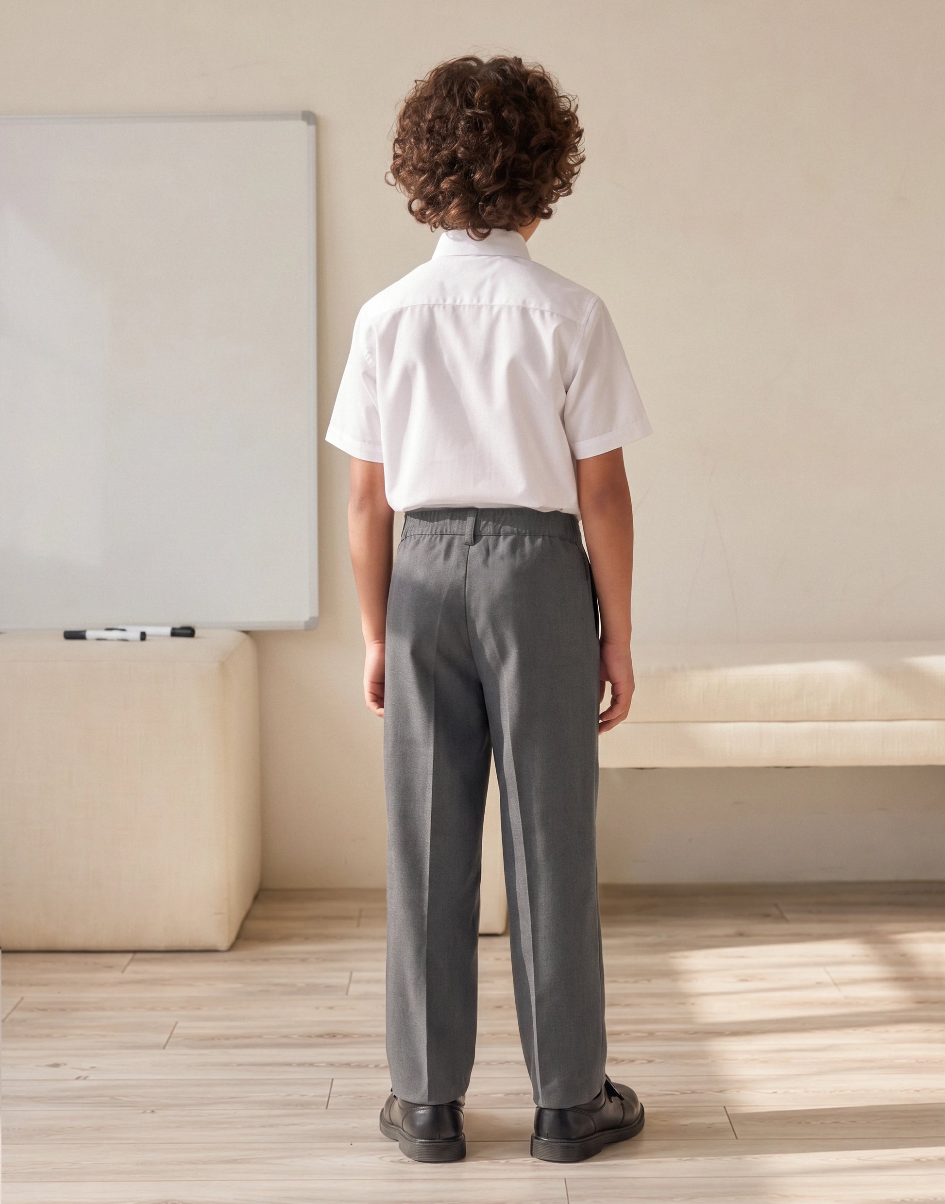 A boy wearing grey 100% GOTS-certified organic cotton school trousers with classic fit back view 