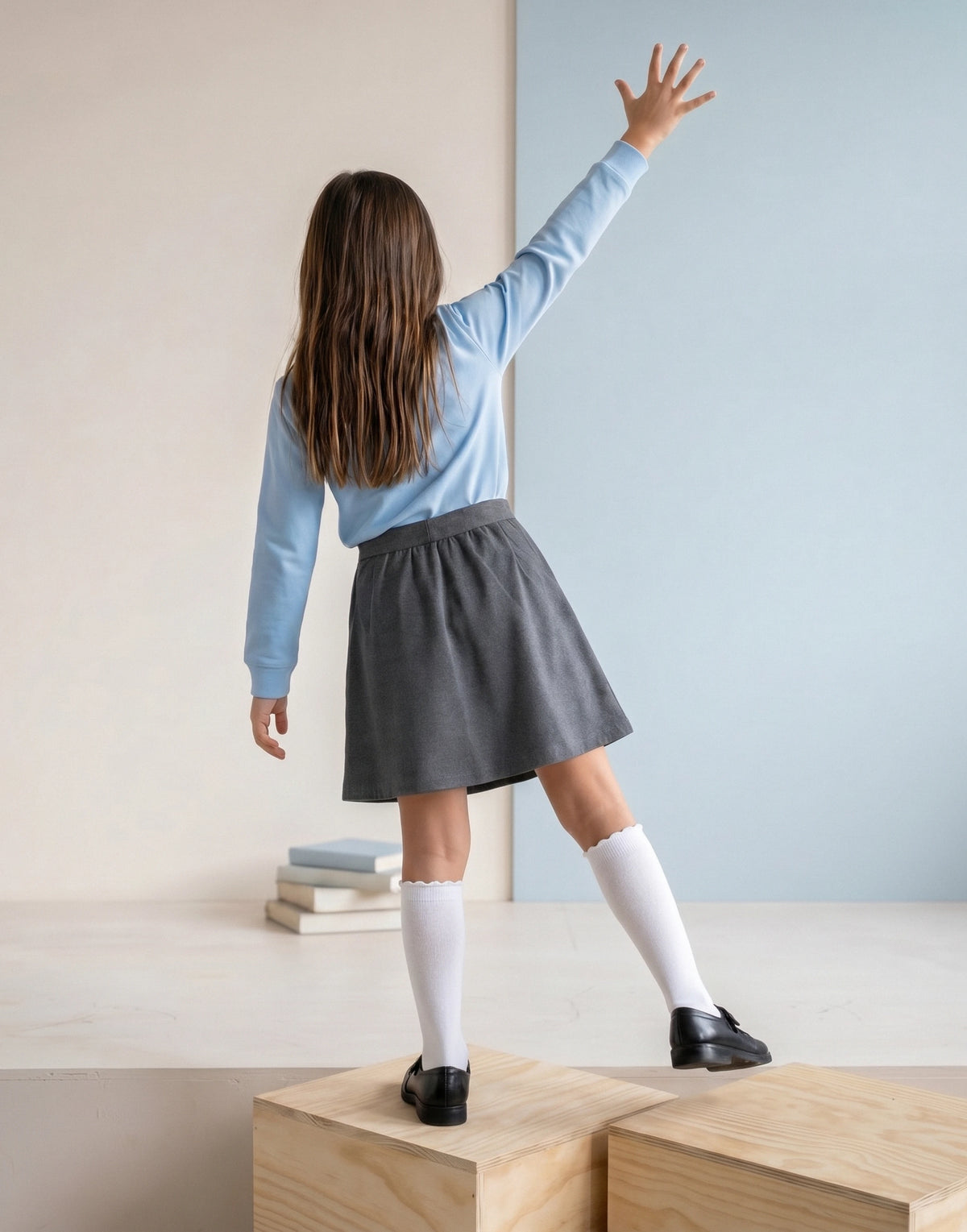 Girl wearing a grey organic cotton jersey school skirt, back view.