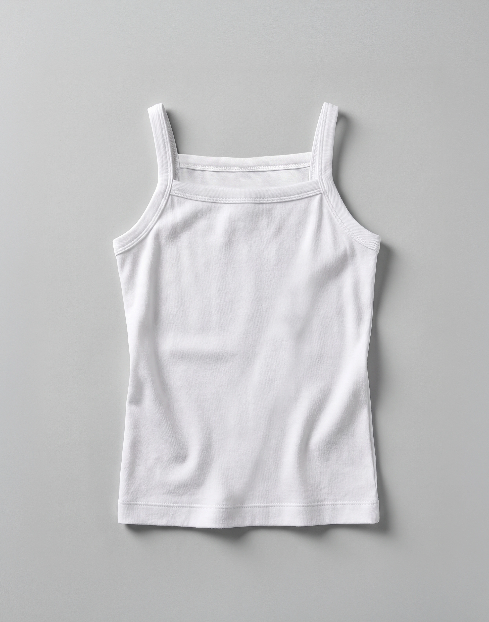 Close-up of the soft organic cotton jersey fabric and slim shoulder straps on the EcoOutfitters girls' camisole vest.