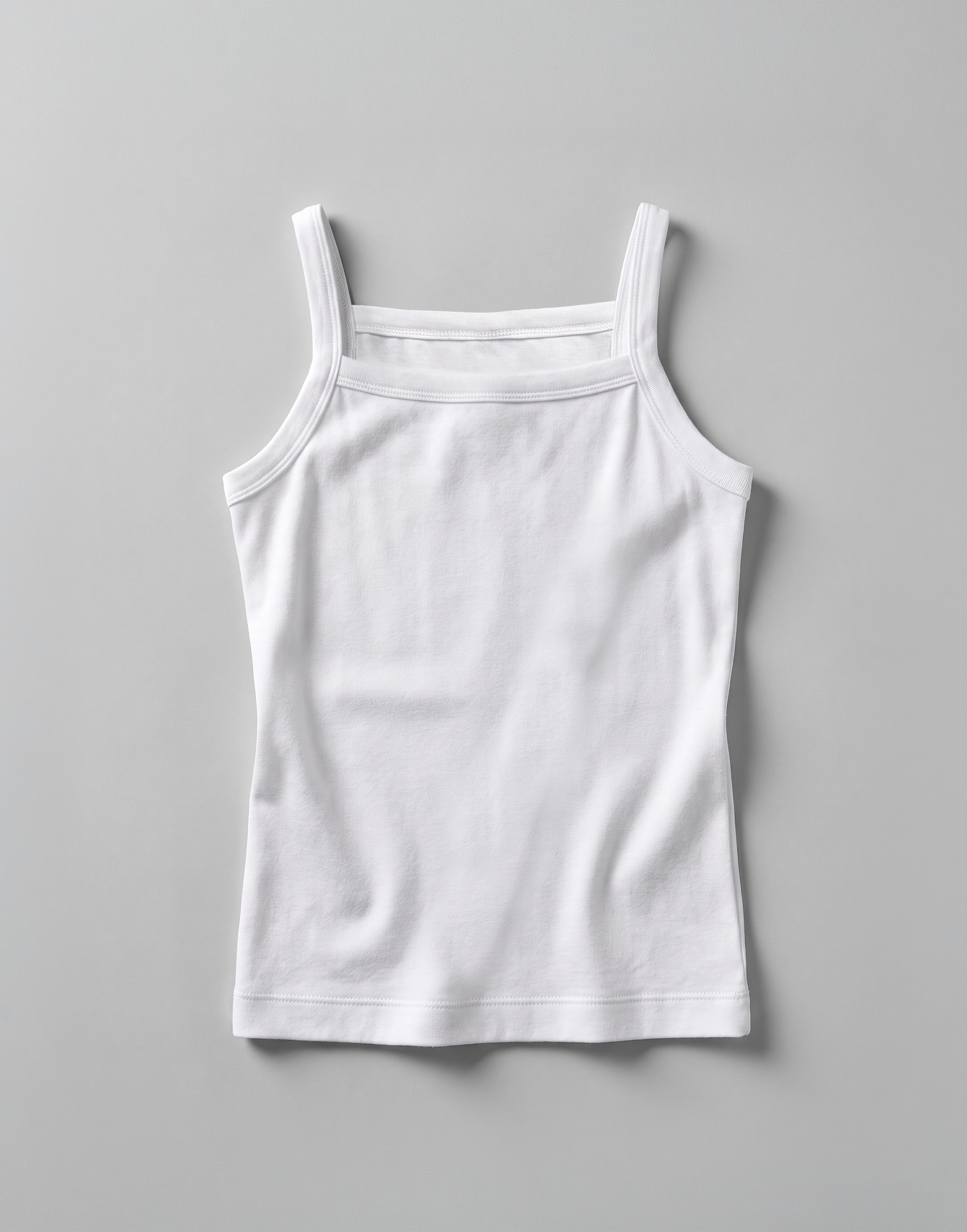 Close-up of the soft organic cotton jersey fabric and slim shoulder straps on the EcoOutfitters girls' camisole vest.