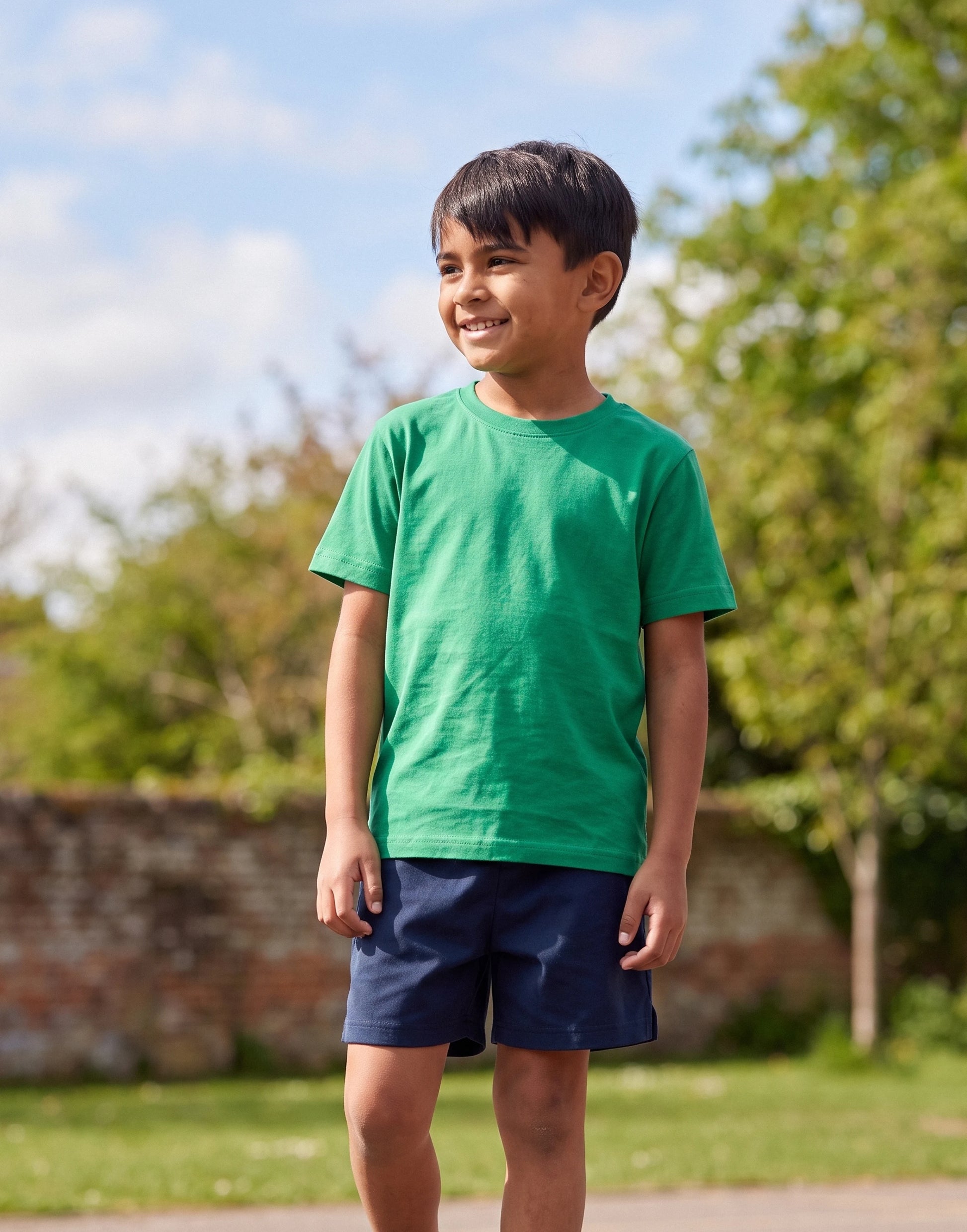 Child wearing a Kelly Green crew neck T-shirt made from 100% GOTS-certified organic cotton, front view.