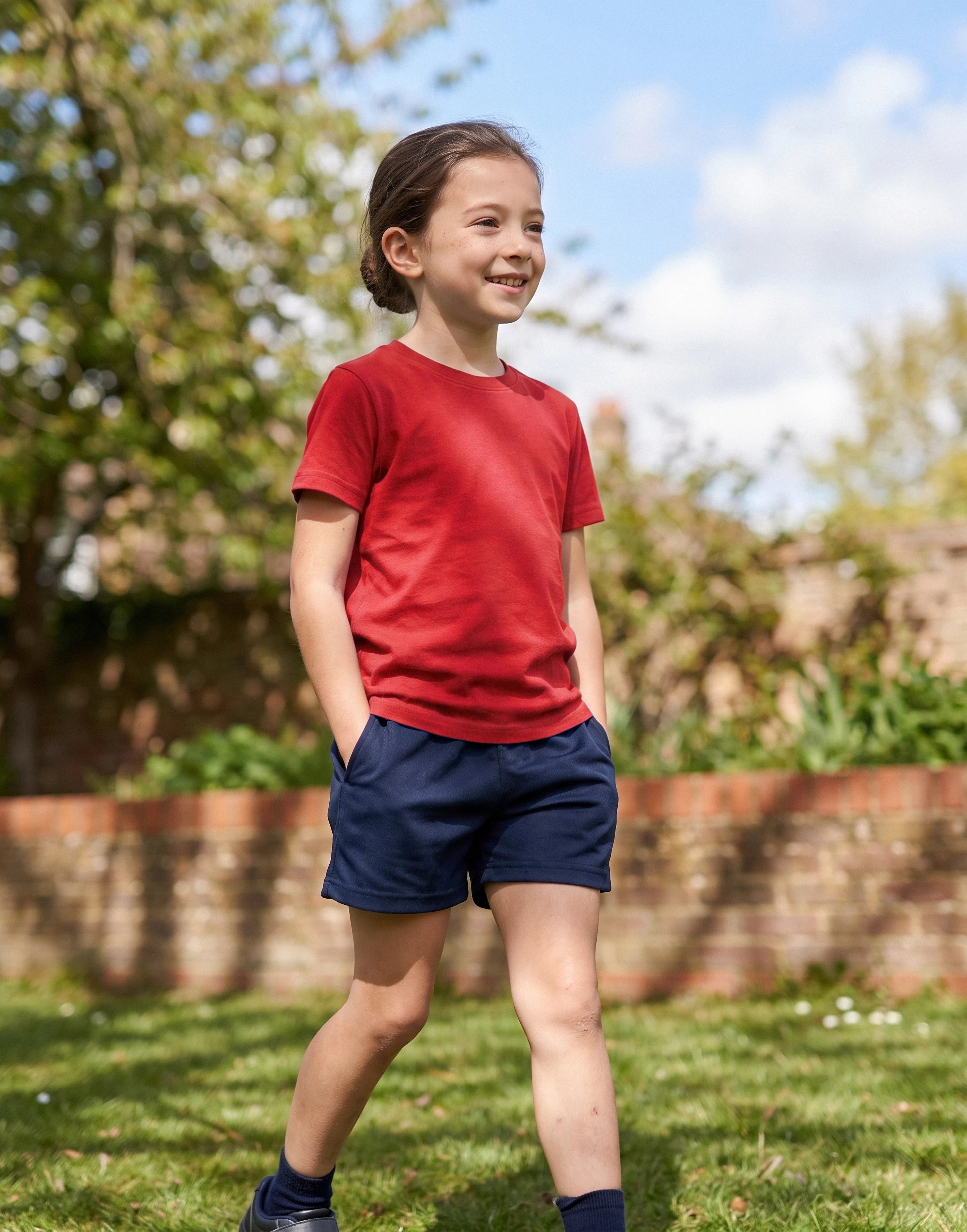 Child wearing a red crew neck T-shirt made from 100% GOTS-certified organic cotton, front view.