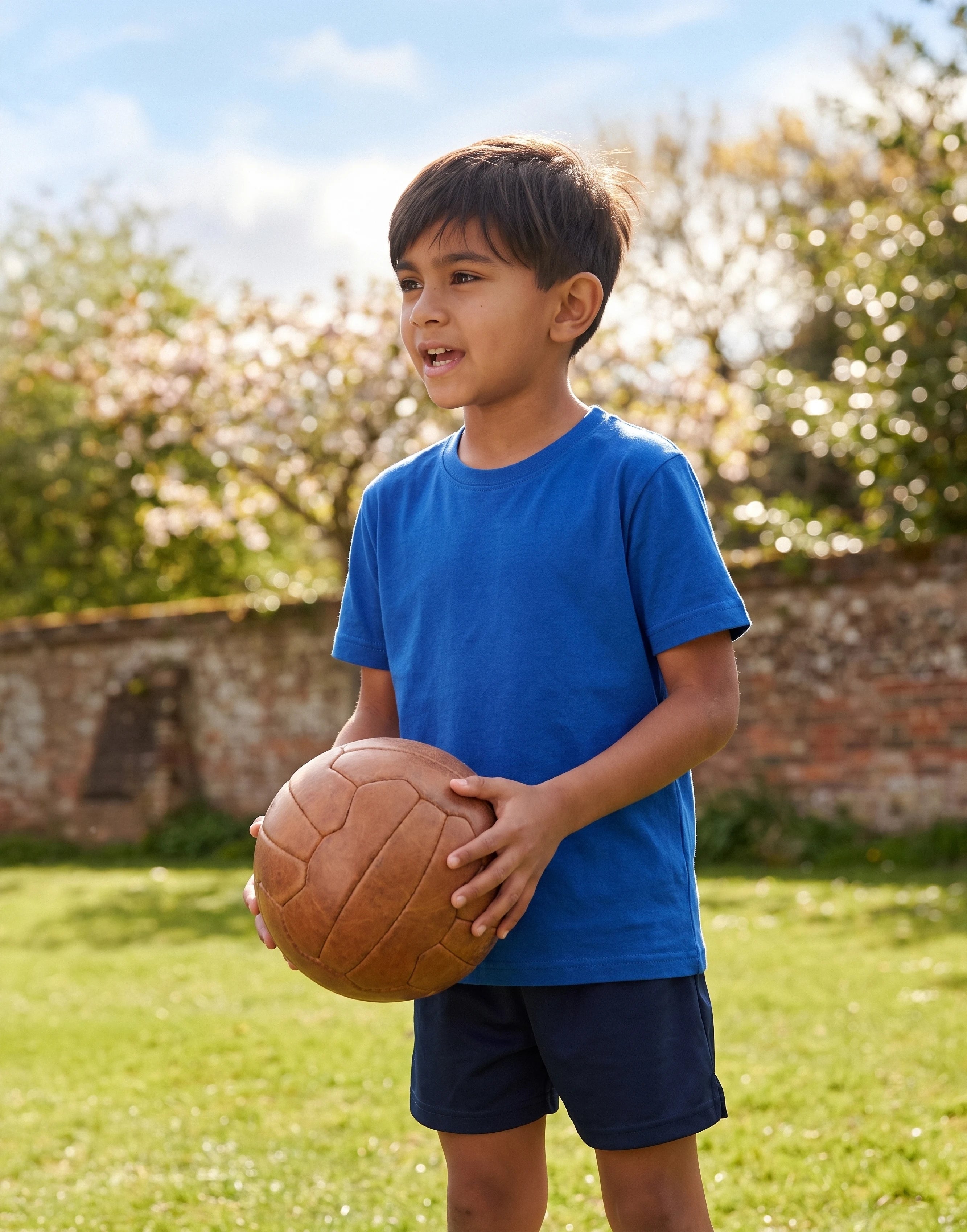 Child wearing a royal blue crew neck T-shirt made from 100% GOTS-certified organic cotton, front view.