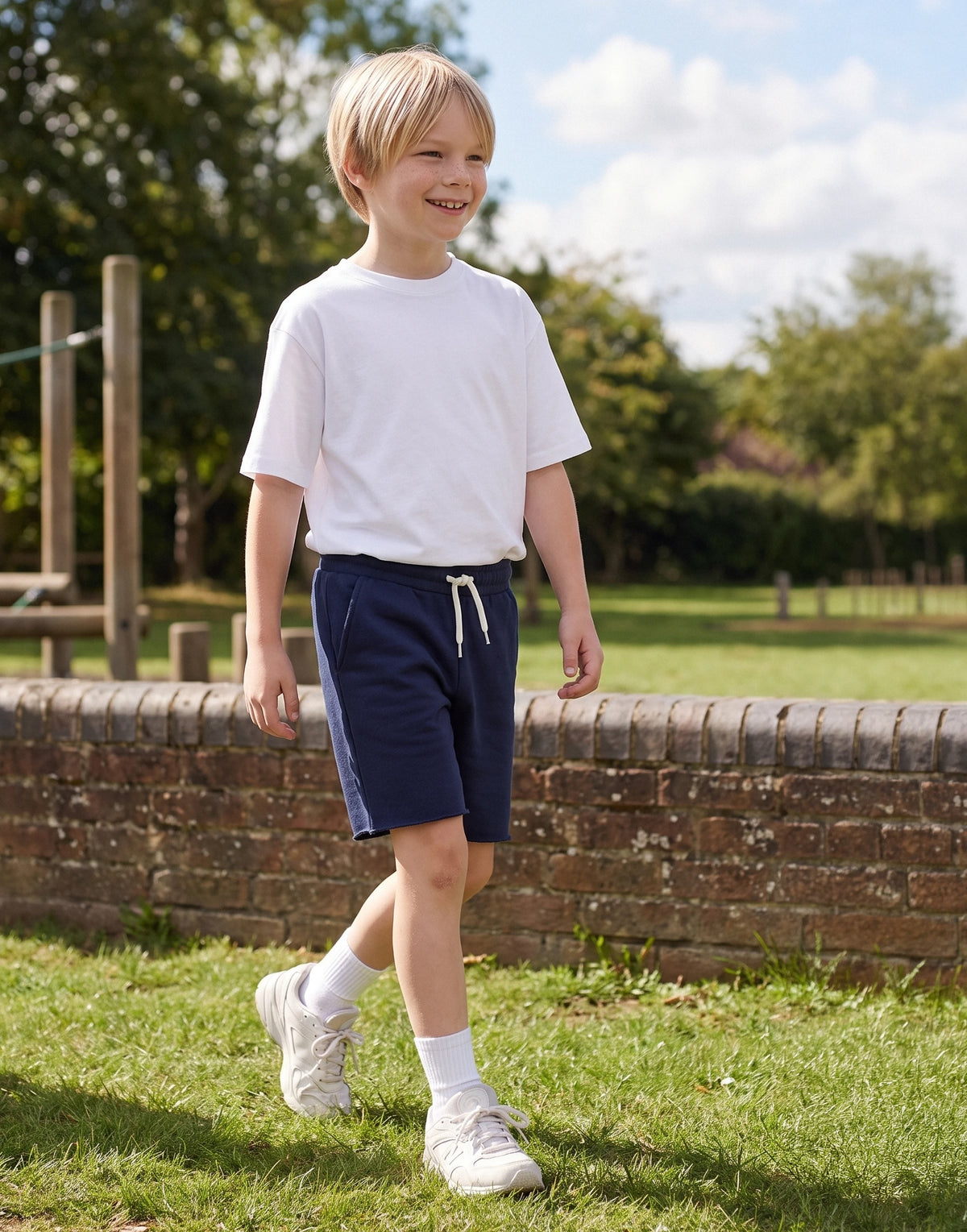 Child wearing navy organic cotton drawstring sweat shorts, front view
