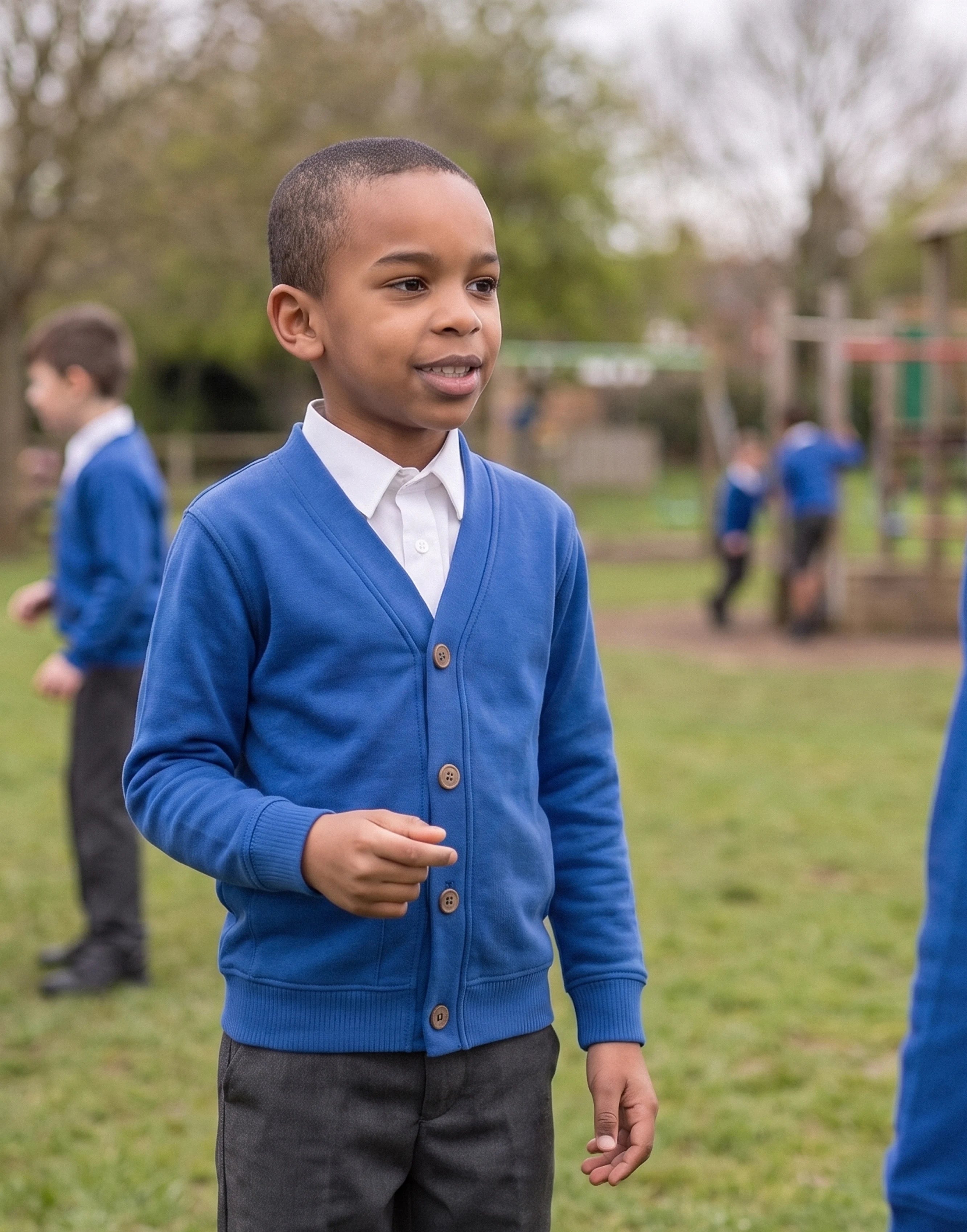 Child wearing a royal blue organic cotton school cardigan with a classic V-neck and button fastening, front view.