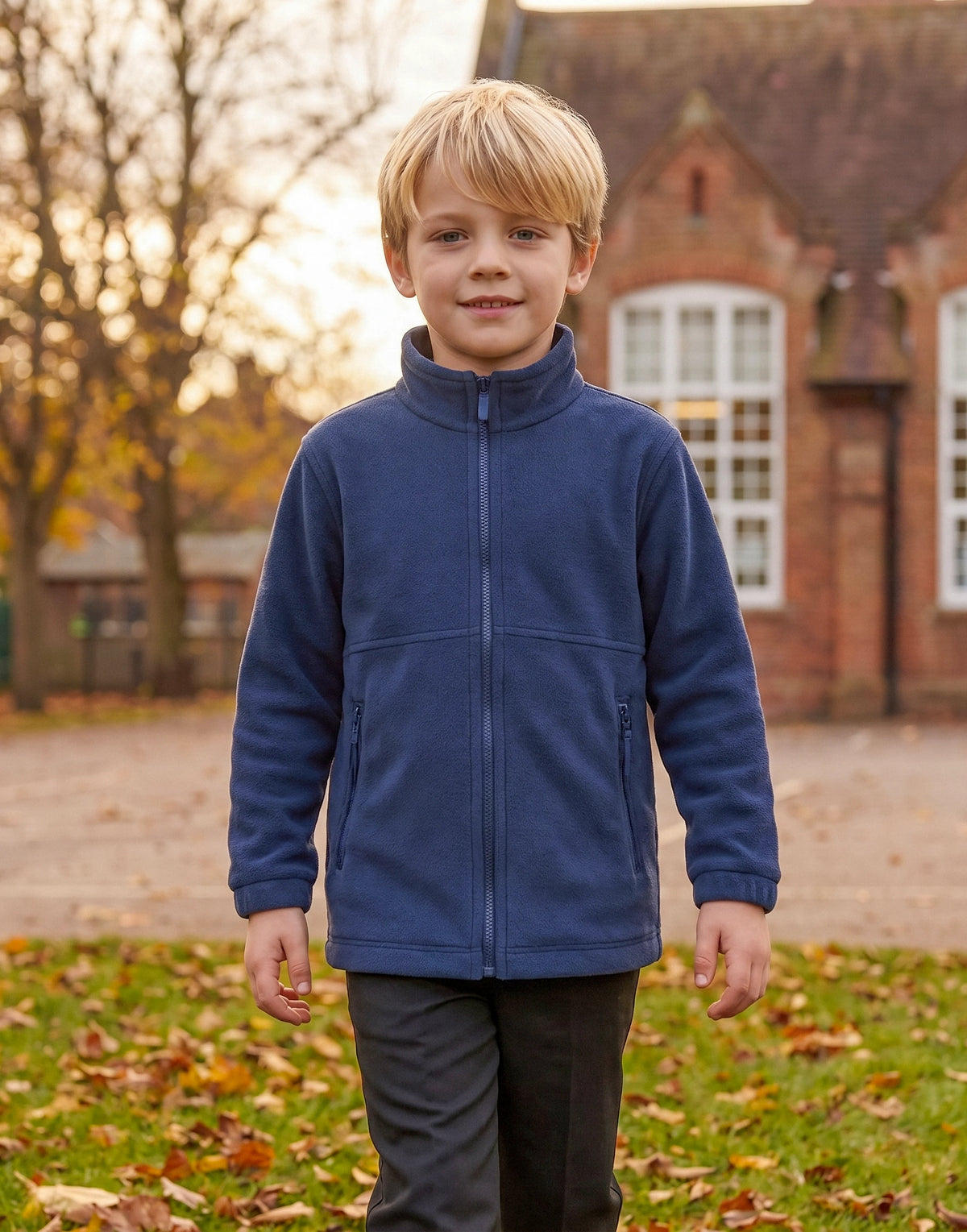 Child wearing a navy school fleece made from 100% GOTS-certified organic cotton, front view.