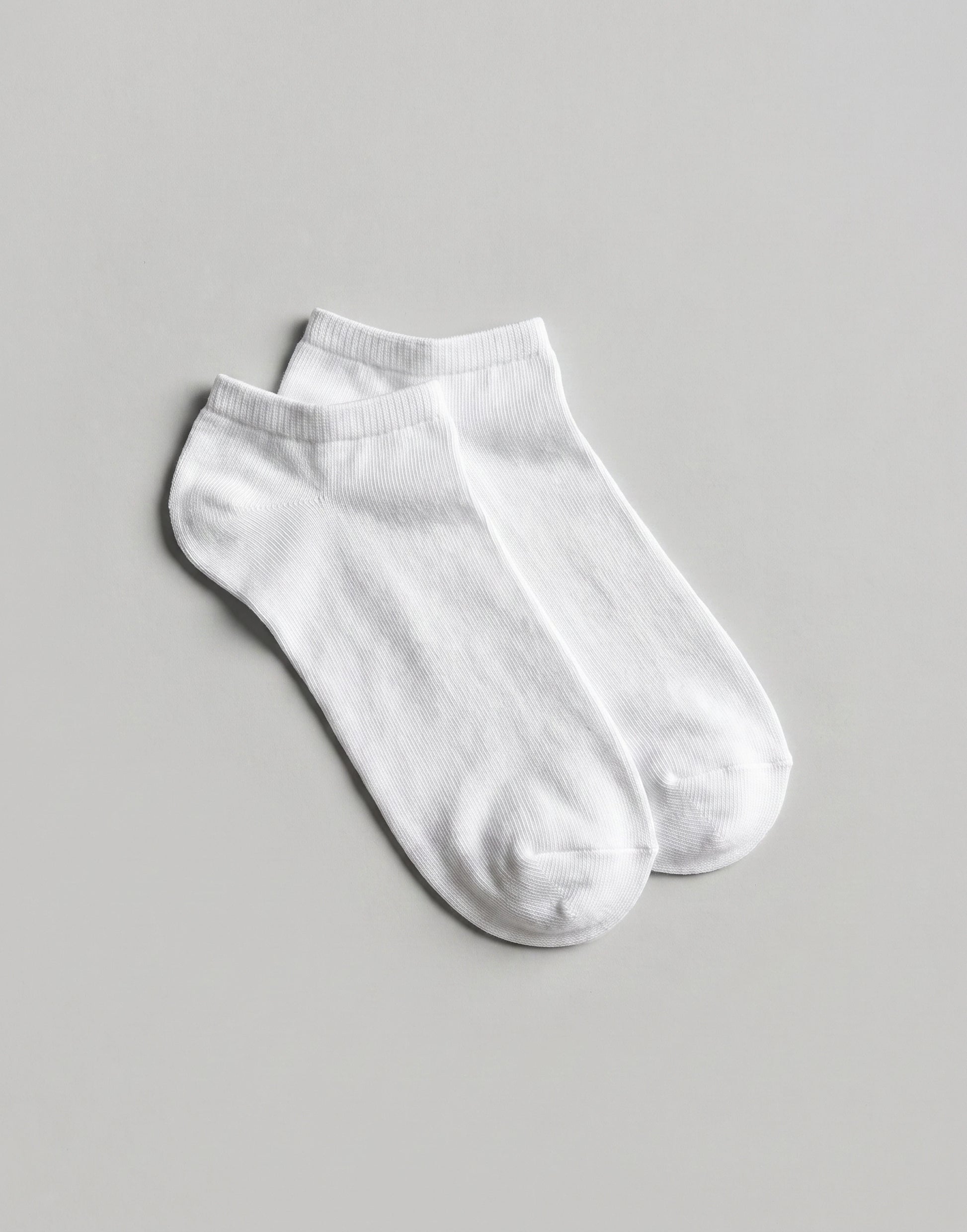 White organic cotton trainer socks with a low-cut design, made from GOTS-certified organic cotton.