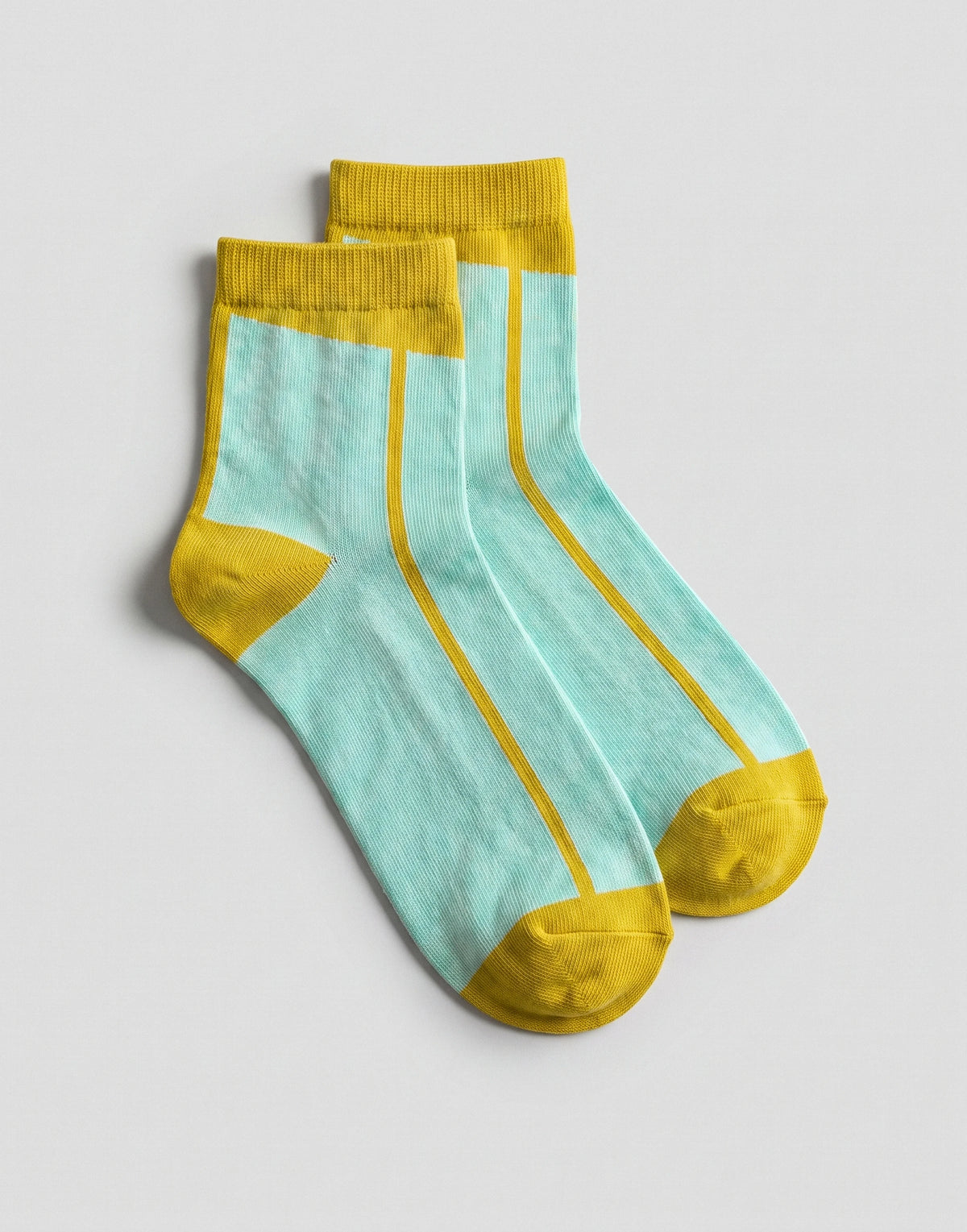 A pair of ankle socks with a light aqua blue body, yellow ribbed cuffs, yellow heels, and yellow toes, displayed on a neutral light gray background.