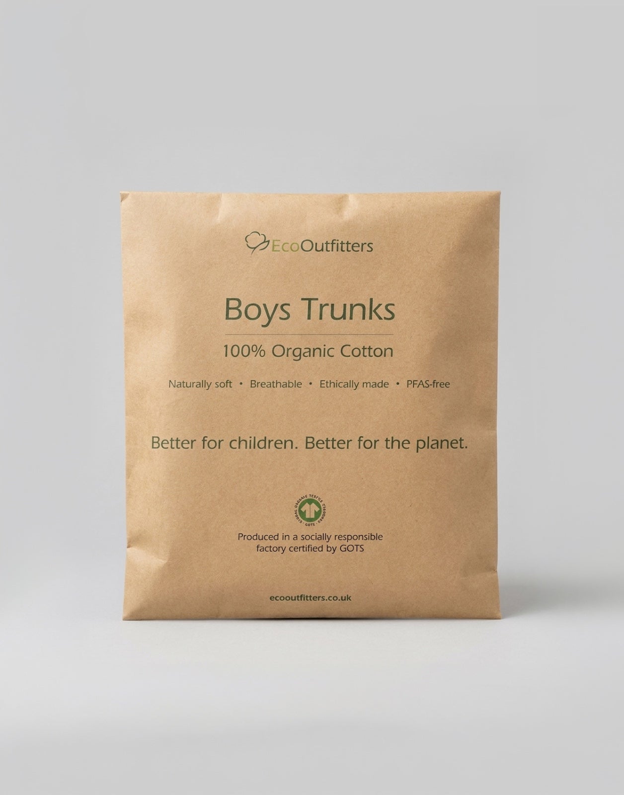 A brown kraft paper pouch of Eco Outfitters Boys Trunks, 100% Organic Cotton, on a neutral gray background.
