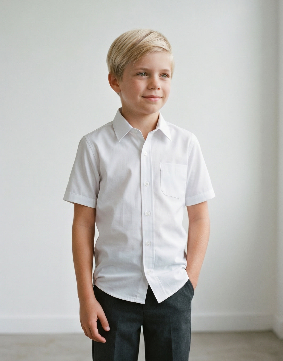 Child wearing a white slim fit short sleeve school shirt made from 100% organic cotton, front view.