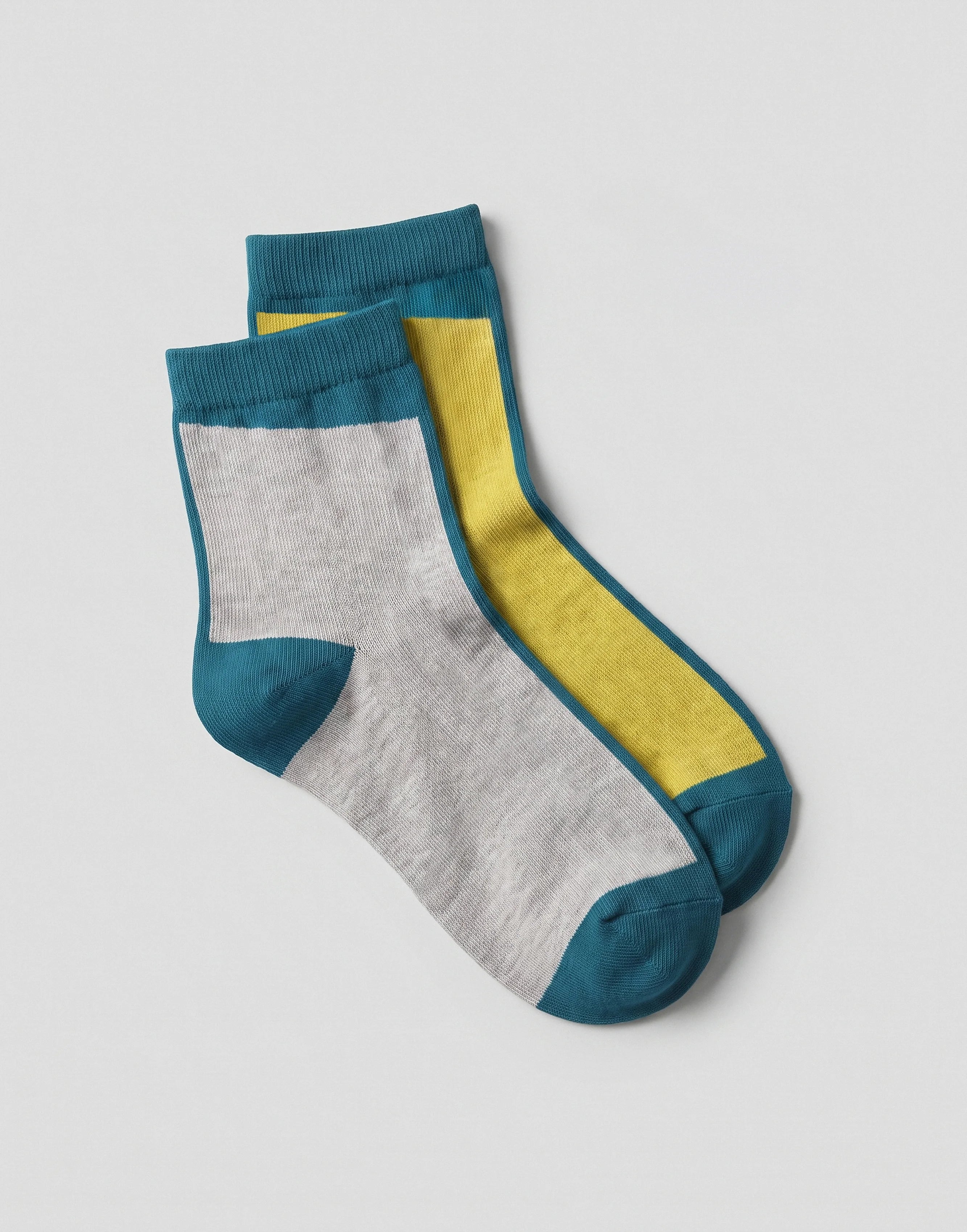 A pair of ankle socks with a color-blocked design, featuring a heather gray main body, a bright yellow inner stripe, and teal blue ribbed cuffs, heels, and toes, displayed on a light gray background.